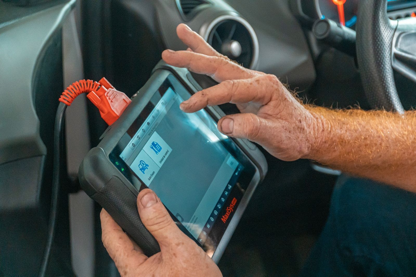 Mechanic using an OBD diagnostic scanner in a car