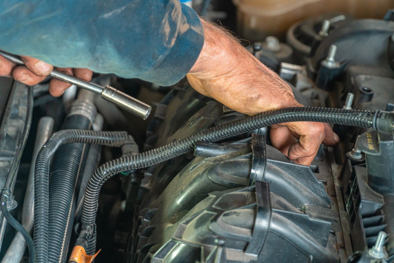 Mechanic's hands repairing a car engine
