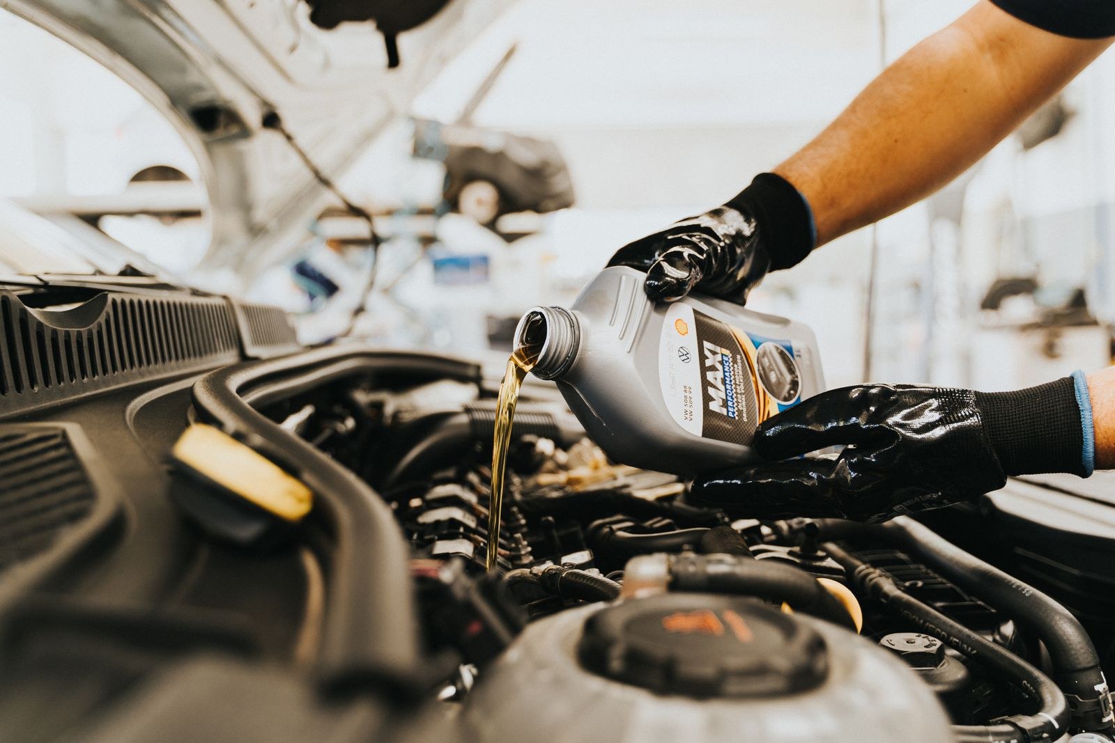 Mechanic pouring fresh oil into a car engine