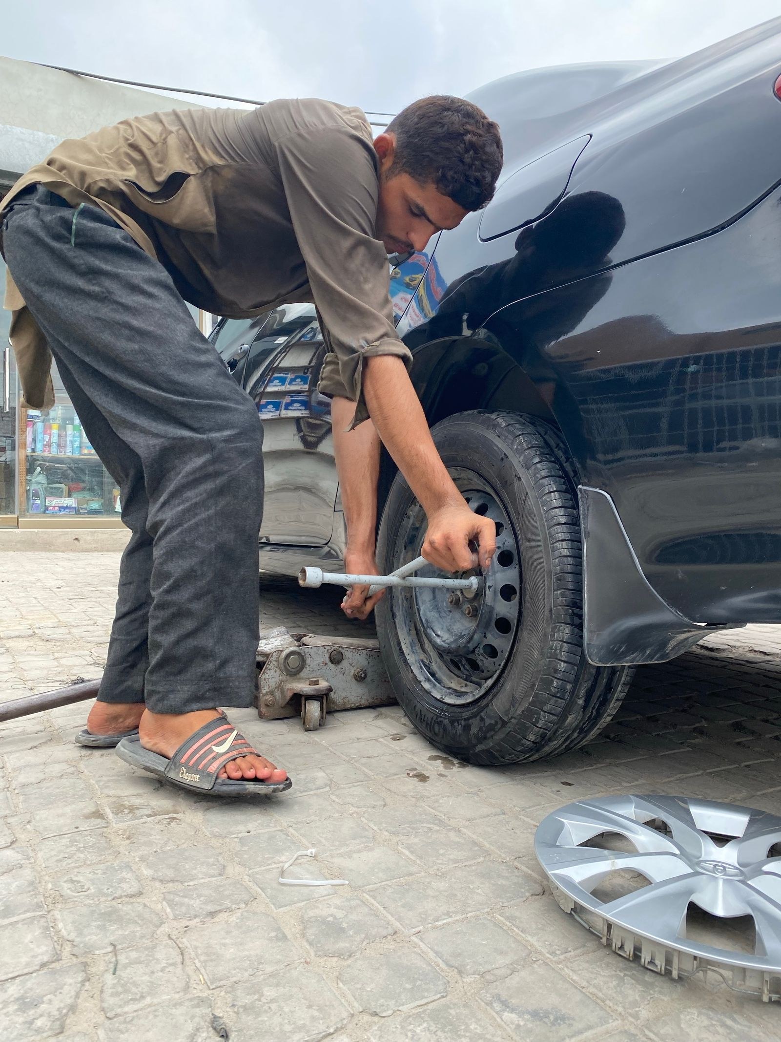 Mechanic using a lug wrench to change a car tire